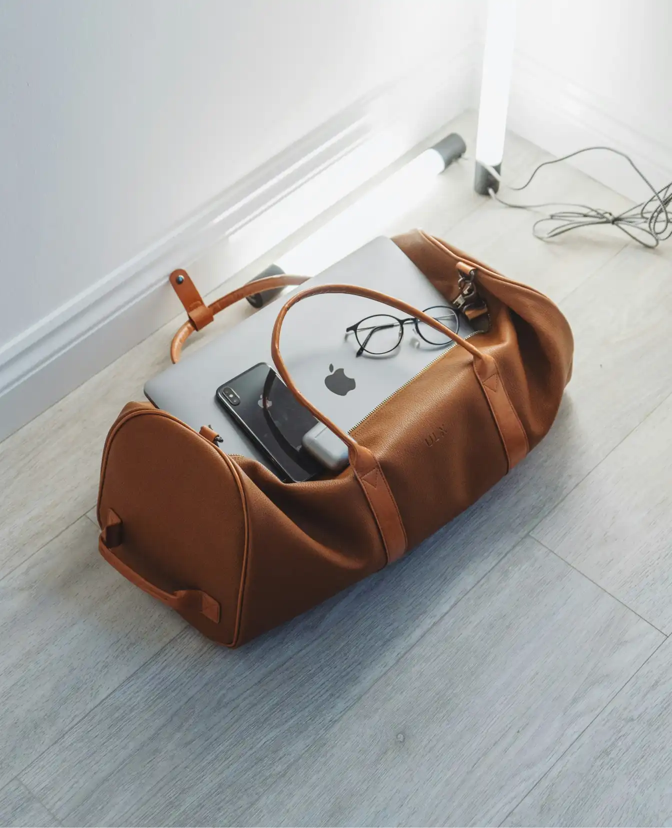 A bag packed with gadgets ready to travel, including an iPhone with a travel eSIM